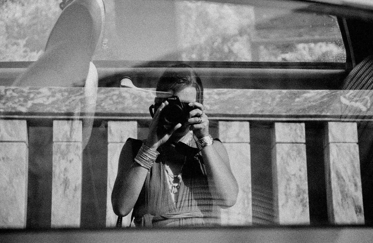 Fotógrafo en inmersión sobre el terreno, cámara en mano